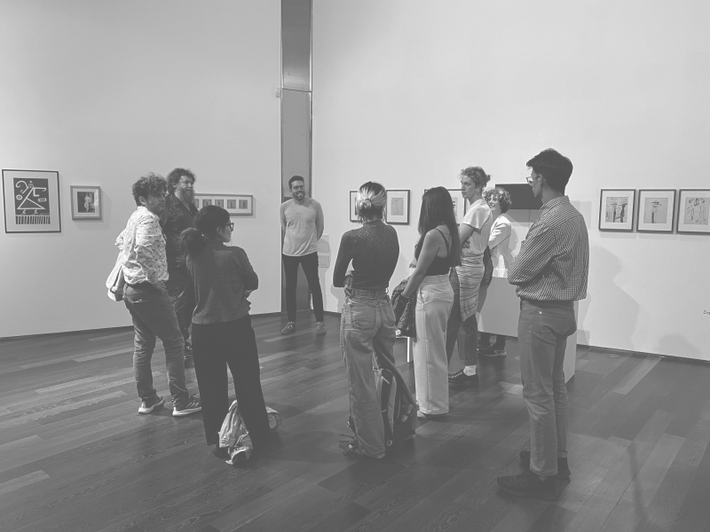Grupo de artistas conversando de pie en sala expositiva