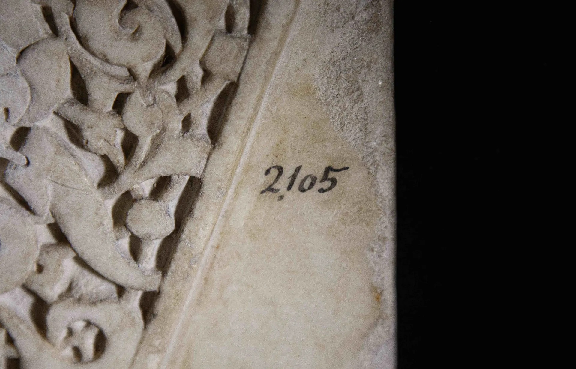 Fotografía detalle de piezas talladas en mármol blanco con decoraciones vegetales y epigrafías