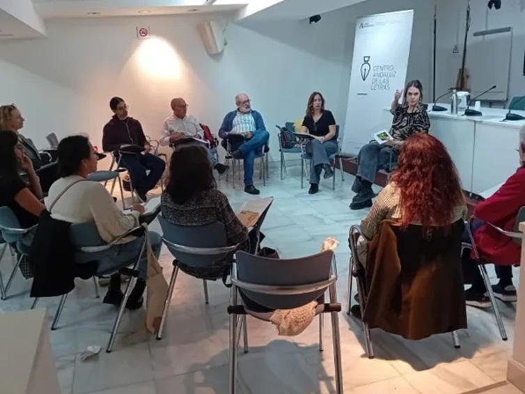 Grupo de personas dialogando sentadas en corro en una sala
