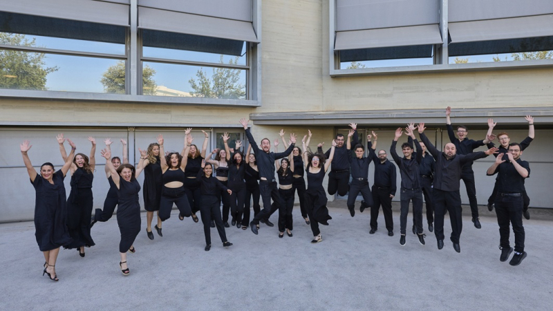 Coro Manuel de Falla UGR Fotografía de los miembros del coro saltando delante del edificio de servicios generales del PTS